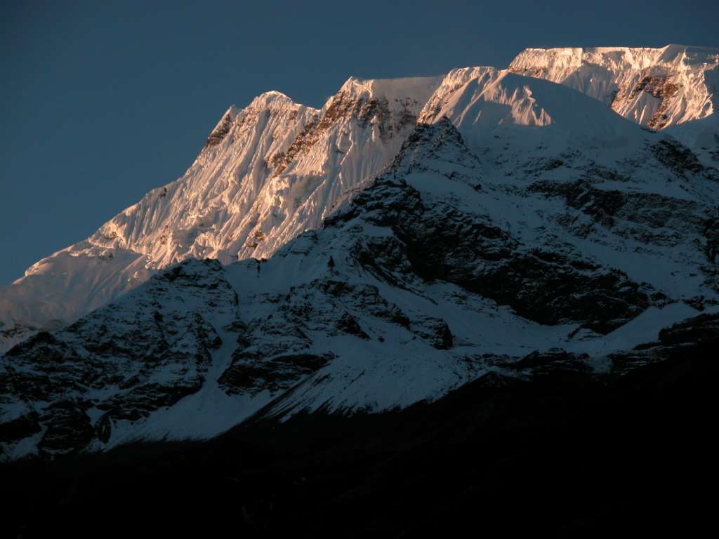 Annapurna 13 02 Annapurna III Sunrise From Manang Annapurna III (7555m) shone in the morning sun from Manang. Annapurna III was first climbed on May 6, 1961 via the Northeast Face by Indian Mohan Kohli, Sonam Gyatso, and Sonam Girmi.